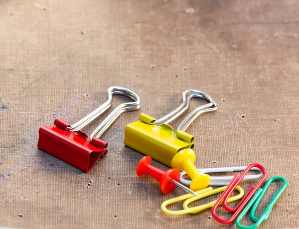 Colorful paper clips set on old paper background