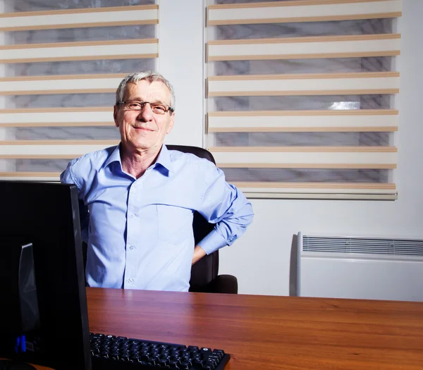 Portrait Of Mature Businessman Suffering From Back Pain