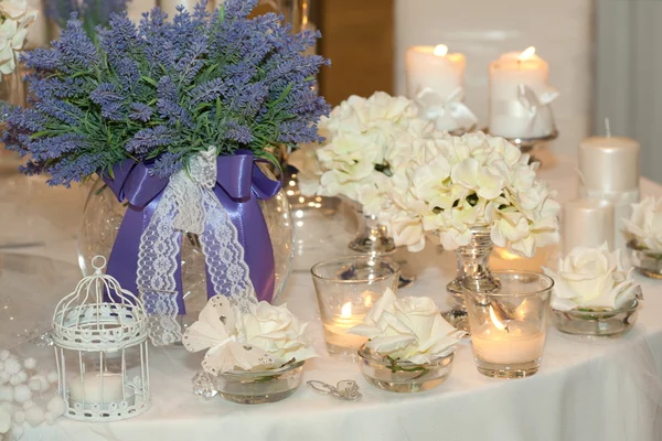 Table decorated with candles, hydrangeas and white roses