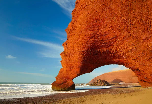 Red archs on atlantic ocean coast. Marocco