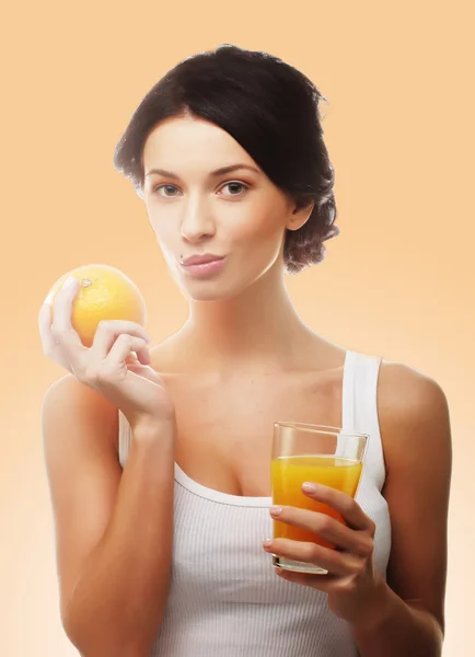 Woman holding orange and juice