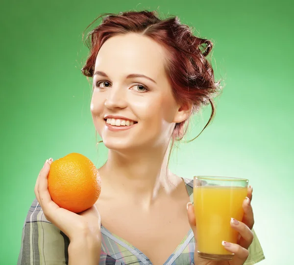 Woman with orange juice over green background