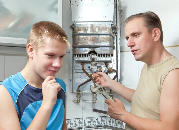 The father and the son-teenager together in repair a gas water heater.