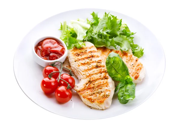 Plate of grilled chicken breast with vegetables
