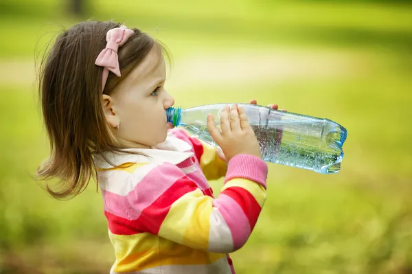 Little girl drinks mineral water