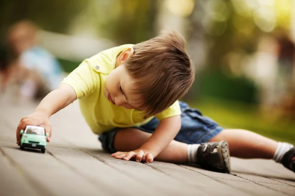 Little boy plays with toy car