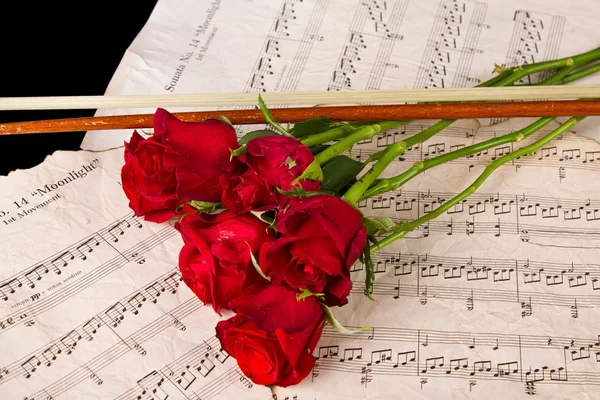 Violin sheet music and rose