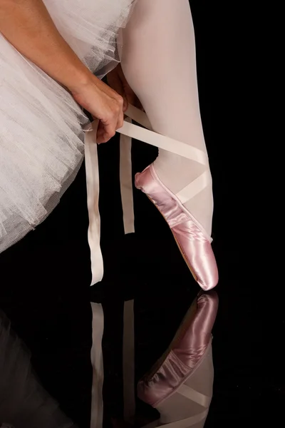 Ballerina put on slippers to prepare for performance with reflec