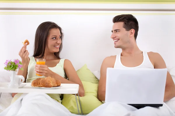 Couple sitting on bed in morning