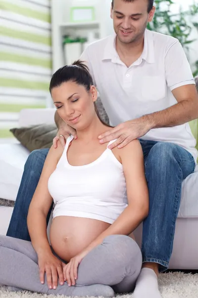 Pregnant woman receiving shoulder massage from her husband