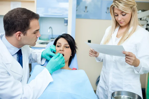 Dentist and a nurse with patient in office