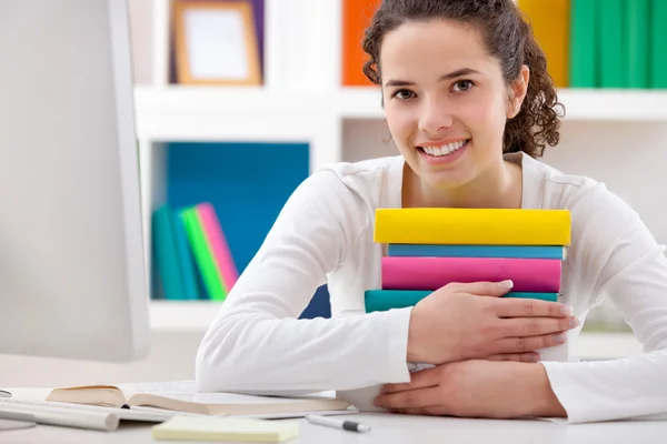 Cheerful girl hugging books