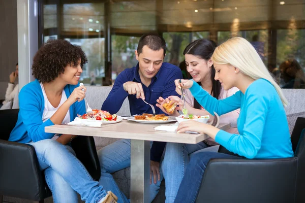 Cheerful teenagers having lunch in restaurant