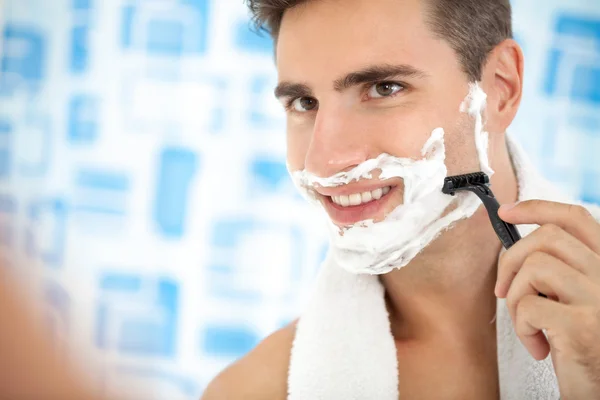 Man shaving his beard with razor