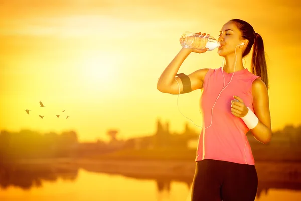 Female jogger drinking water