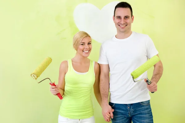 Portrait of love couple with paint rollers