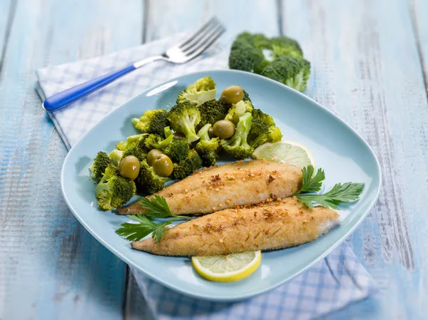 Breaded fish with broccoli and olives, selective focus
