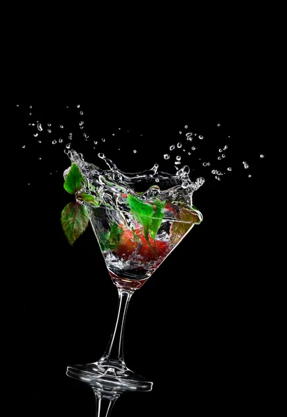 View of martini glass with strawberry on black background