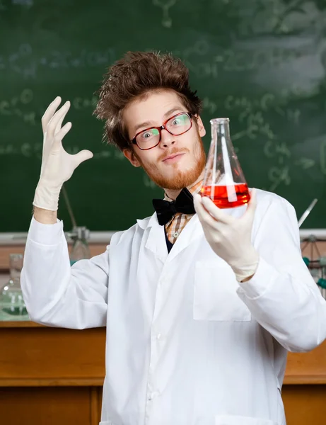 Mad professor admires his experimental red liquid