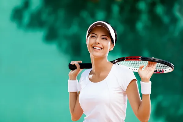 Successful sportswoman with racket at the tennis court