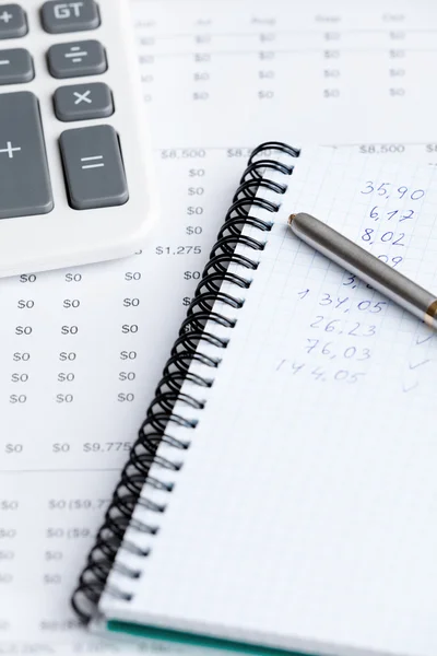 Close up of business writing pad, pen, calculator