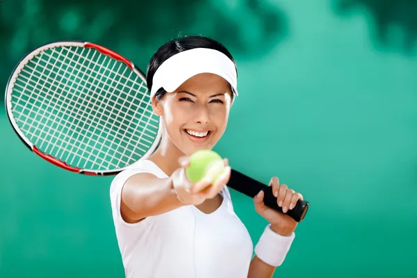 Sporty woman serves tennis ball