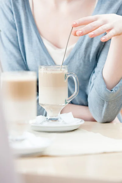 Woman is stirring the milk shake