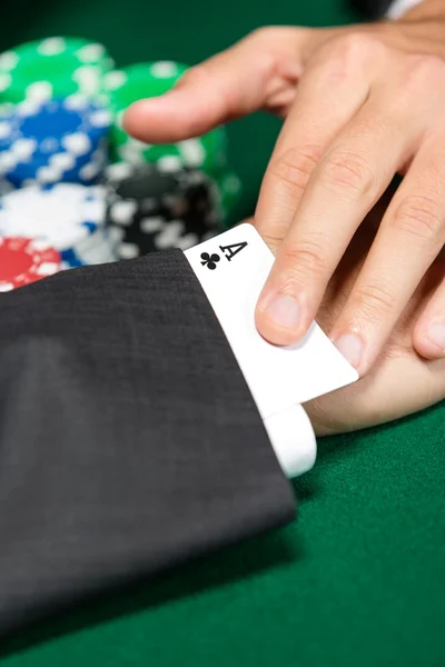 Poker player cheats with card from the sleeve