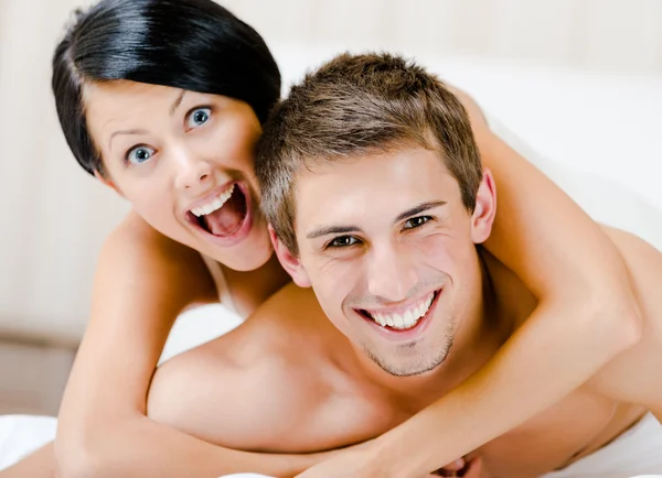 Close up view of laughing couple who plays in bedroom