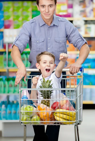 Little boy sitting in shopping trolley