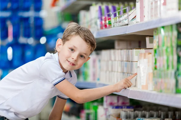 Little boy chooses cosmetics in the store
