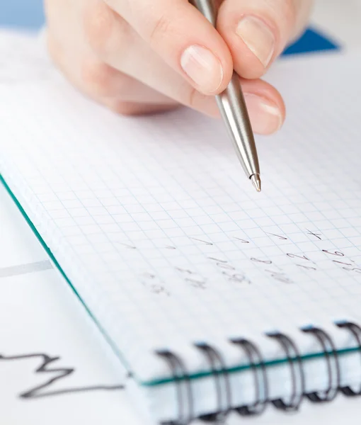 Close up of hand writing in the writing pad