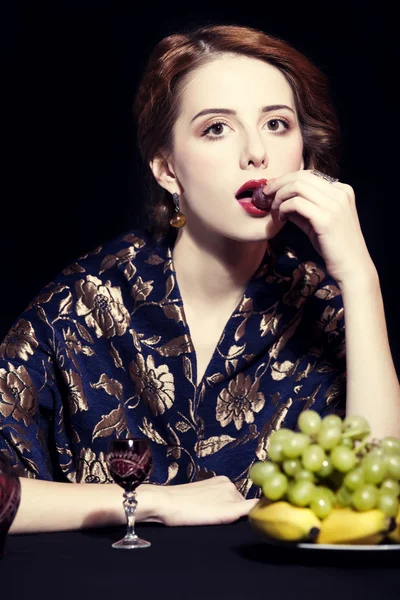 Portrait of beautiful rich women with grapes.