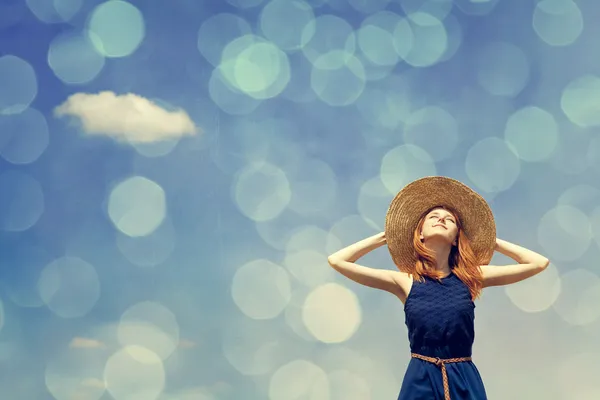 Redhead girl at spring blue sky background.