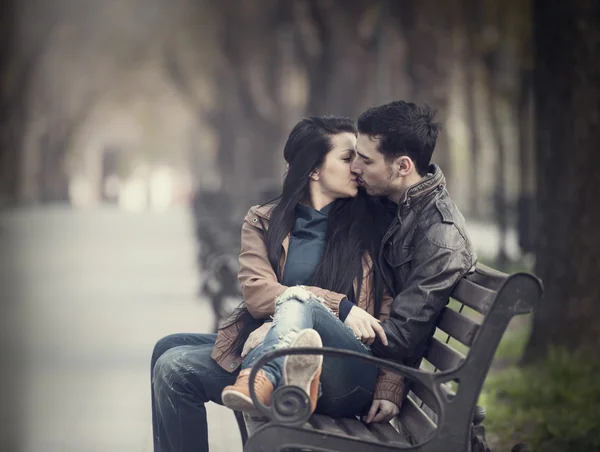 Couple kissing at the bench at alley.