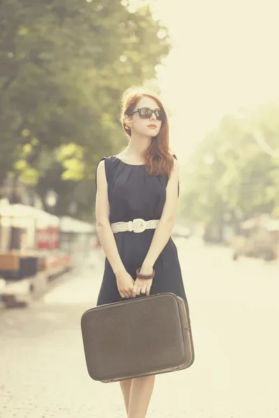 Young woman with suitcase on the city street