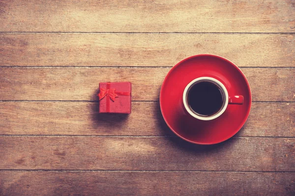Little red gift and cup of the coffee.