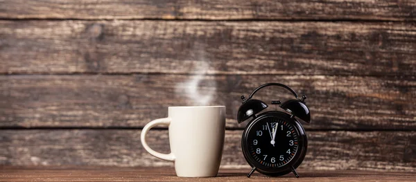 Tea or coffee cup and alarm clock