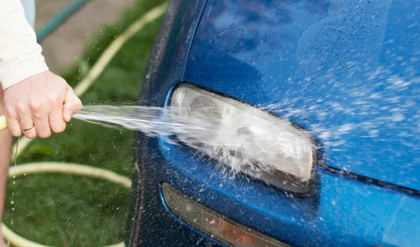 The process of washing cars headlights with a hose with water
