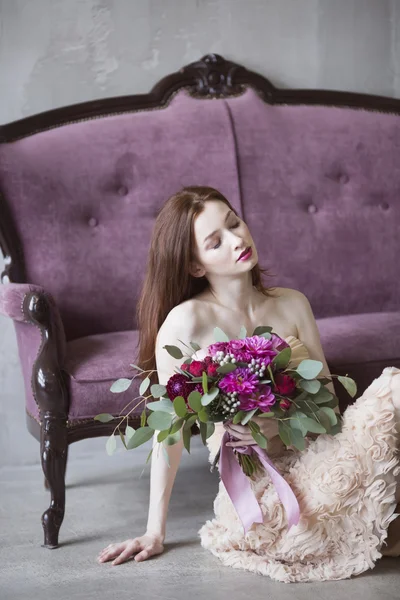 Luxury bride in a pink dress with a wedding bouquet in the wine