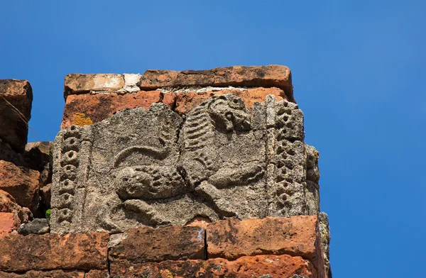 Old cracked bas-relief of lion on the facade of ancient temple