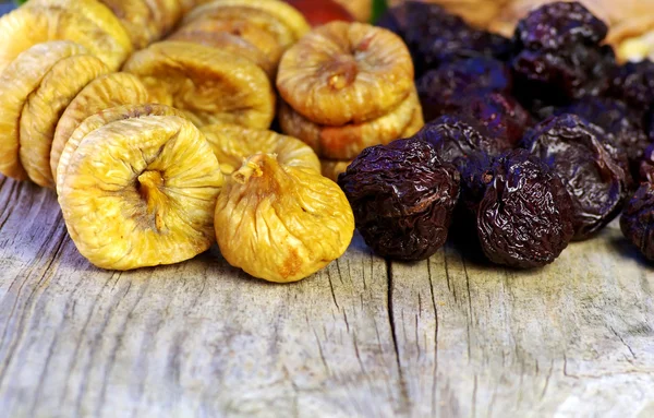 Dried plums and figs in wooden table
