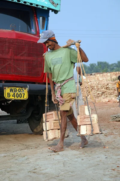 Brick field workers carrying complete finish brick from the kiln, and loaded it onto a truck