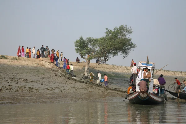 Wooden boat crosses the Ganges River in Gosaba, West Bengal, India.