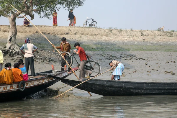 Wooden boat crosses the Ganges River in Gosaba, West Bengal, India.