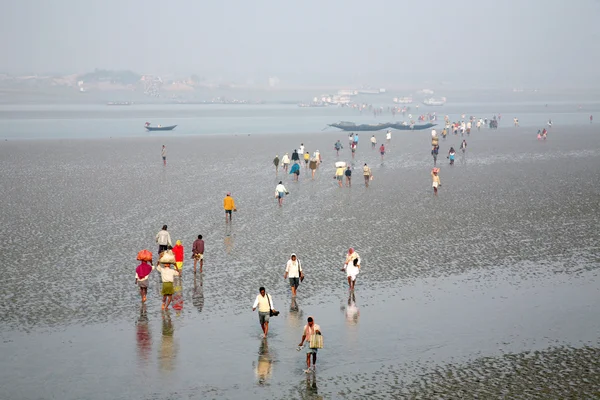 During low tide the water in the river Malta falls so low that people walk to the other shore in Canning Town, India