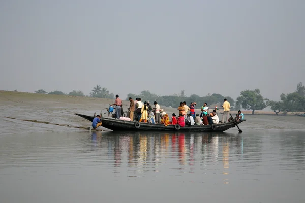 Wooden boat crosses the Ganges River in Gosaba, West Bengal, India