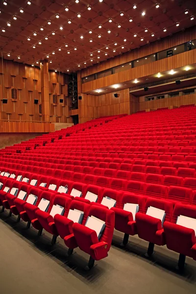 Interior of empty hall with red arm-chairs