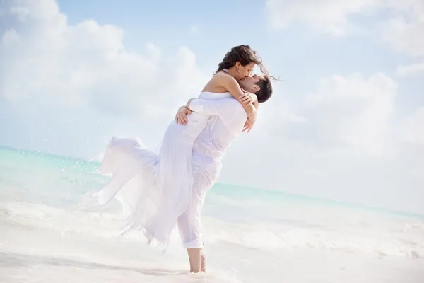 Bride and groom kissing on a tropical beach