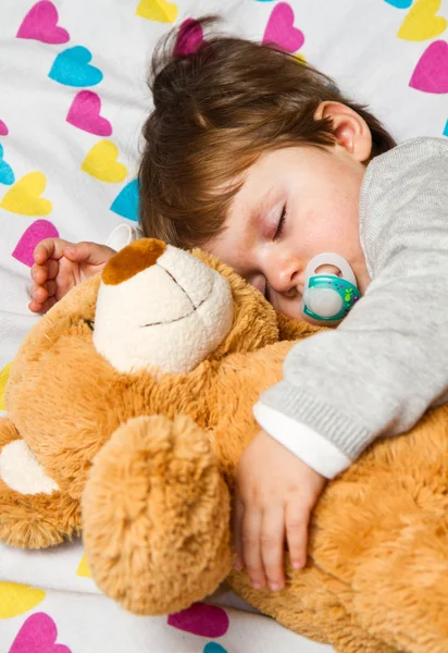 Sweet child sleeping with teddy bear